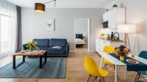 a living room with a blue couch and yellow chairs at Finale Apartments in Krakow