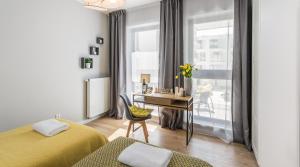 een slaapkamer met 2 bedden, een bureau en een raam bij Finale Apartments in Krakau