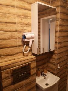 łazienka z umywalką i telefonem na ścianie w obiekcie Traditional Boutique w Braszowie