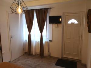 Pokój z drzwiami, oknem i telewizorem w obiekcie Traditional Boutique w Braszowie