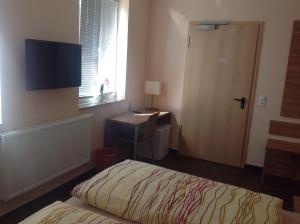 a bedroom with a bed and a desk and a window at Pension an der Werft in Rostock