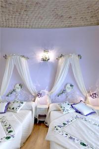 2 Betten in einem Zimmer mit lila Wänden in der Unterkunft La Maison Rosa Stella in Lucera