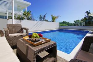 a bowl of fruit on a table next to a swimming pool at Villa Napa View in Ayia Napa