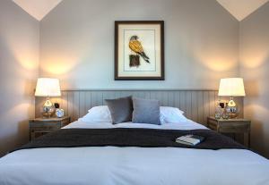 a bedroom with a large bed with two lamps at The Ferry Boat Inn in North Fambridge