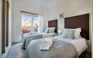 une chambre d'hôtel avec deux lits et un balcon dans l'établissement Penthouse Apartment Royal Cabanas Resort, à Cabanas de Tavira