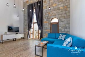 a living room with a blue couch and a brick wall at Cascadas Family Resort in Sunny Beach