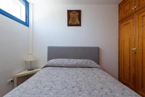 1 dormitorio con 1 cama con edredón azul en Seaside Villa - Agaete, en Agaete