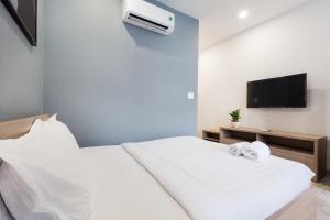 a bedroom with two white beds and a flat screen tv at YOURS studio airport in Ho Chi Minh City