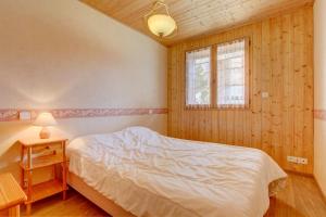 een slaapkamer met een wit bed en een raam bij LES SERMES 1 in Morzine