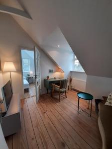 ein Wohnzimmer mit einem Sofa und einem Schreibtisch im Dachgeschoss in der Unterkunft LatterLy Rooms in Silkeborg