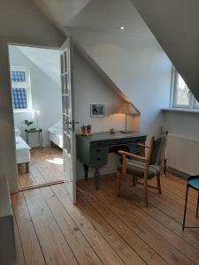 Zimmer im Dachgeschoss mit einem Schreibtisch und einem Stuhl in der Unterkunft LatterLy Rooms in Silkeborg