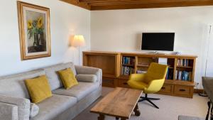 a living room with a couch and a tv at Allod Bad 601 in St. Moritz
