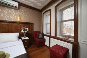 een slaapkamer met een bed, een stoel en een raam bij Medar Otel in Istanbul
