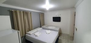 a small room with a bed and a television at Pousada Veleiro in Fortaleza