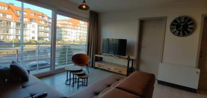 uma sala de estar com um sofá e uma grande janela em Sans Souci - residentie Neoportus em Nieuwpoort