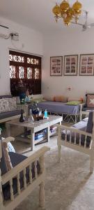 a living room with couches and tables and chairs at VILLA SANDRIN-Near White Town and Beach in Puducherry