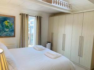 a bedroom with a white bed and a window at Shepherds House in Swanage