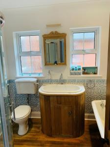 a bathroom with a sink and a toilet and a tub at Shepherds House in Swanage