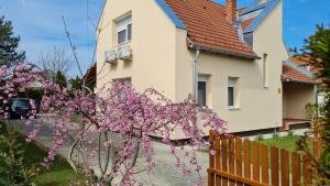 a house with pink flowers in front of a fence at Anna villa in Lenti
