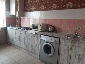 a kitchen with a washing machine and a microwave at Yanovskogo 3k in Kropyvnytskyi