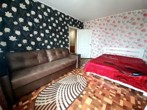 uma sala de estar com um sofá e uma parede floral em Яновского 3к em Kropyvnytskyi
