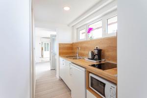 a kitchen with white cabinets and a sink at Villa King Apartments in Brela