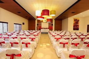 a banquet hall with white chairs and a podium at Park Residency Adoor in Adūr