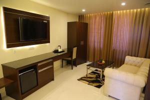 a living room with a television and a couch and a table at VSR GRAND in Madanapalle