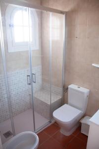 uma casa de banho com um chuveiro, um WC e um lavatório. em Homenfun Menorca Playa de Fornells II em Fornells