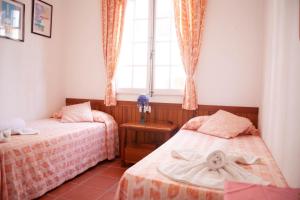 Un dormitorio con dos camas y una ventana. en Homenfun Menorca Playa de Fornells II, en Fornells
