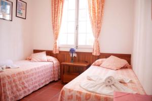 a bedroom with two beds and a window at Homenfun Menorca Playa de Fornells II in Fornells