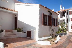 un edificio blanco con escaleras y una puerta en Homenfun Menorca Playa de Fornells II, en Fornells