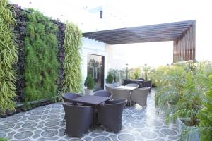 an outdoor patio with tables and chairs and plants at VSR GRAND in Madanapalle