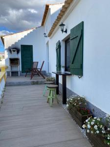 a patio with a table and bench on a house at Casa Alfazema do Monte in Santa Marta