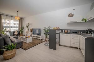 a kitchen and living room with a couch and a table at Apartamenty Rejtana in Leszno