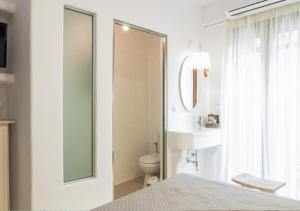 Un baño con inodoro, lavabo y espejo. en Sea & City Naxos, en Naxos Chora 43 fotos más