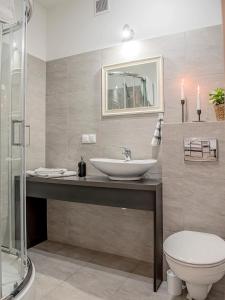 a bathroom with a sink and a toilet at Apartamenty Rejtana in Leszno