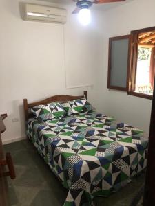 a bedroom with a bed in a room at Guarda do Embaú Aluguél Casa 300mts Praia in Guarda do Embaú