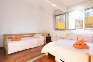 a bedroom with two beds and two windows at Lets Holidays Terrace Barcelona in Barcelona