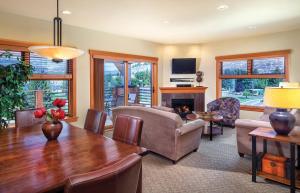 uma sala de estar com uma mesa de madeira e uma sala de estar com lareira em WorldMark Chelan - Lake House em Chelan