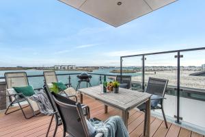 a patio with a table and chairs on a balcony at Dock 76 Bridge - Penthouse in Olpenitz