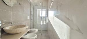 a bathroom with a stone sink and a toilet at Villaggio Camping Oasi in Vieste