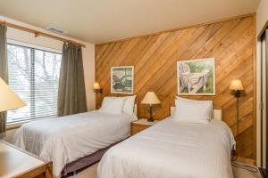 two beds in a hotel room with wood paneling at Ridge - 2682 in Elkhorn Village