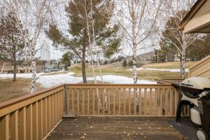 een houten terras met een sneeuwbedekte tuin en bomen bij Ridge - 2682 in Elkhorn Village