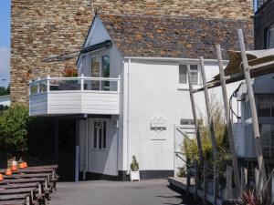 a white building with a balcony on the side of it at The Boathouse in Kingsbridge