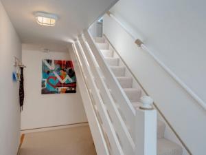 a white staircase in a house with a painting at The Boathouse in Kingsbridge