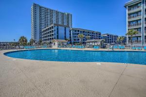 una piscina con sillas y un edificio alto en Cozy Myrtle Beach Escape with Resort Amenities!, en Myrtle Beach
