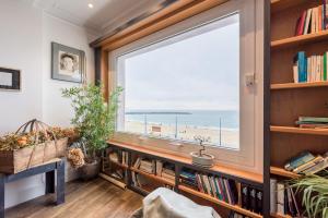Pokój z dużym oknem z widokiem na plażę w obiekcie Colon Zurriola IB Apartments w mieście San Sebastián