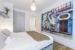 biała sypialnia z dużym obrazem na ścianie w obiekcie Colon Zurriola IB Apartments w mieście San Sebastián