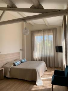 a bedroom with a large bed and a window at Le Castelet des Alpilles in Saint-Rémy-de-Provence
